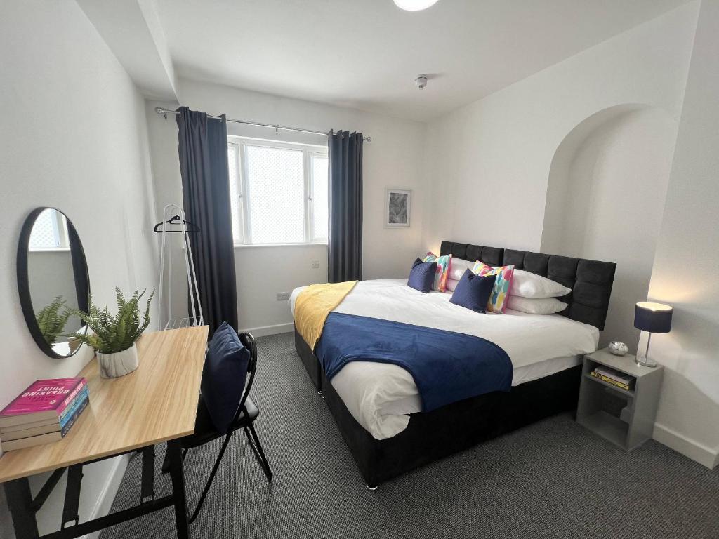 - une chambre avec un lit, un bureau et un miroir dans l'établissement Stay - The Wellington Burton on Trent, à Burton-on-Trent