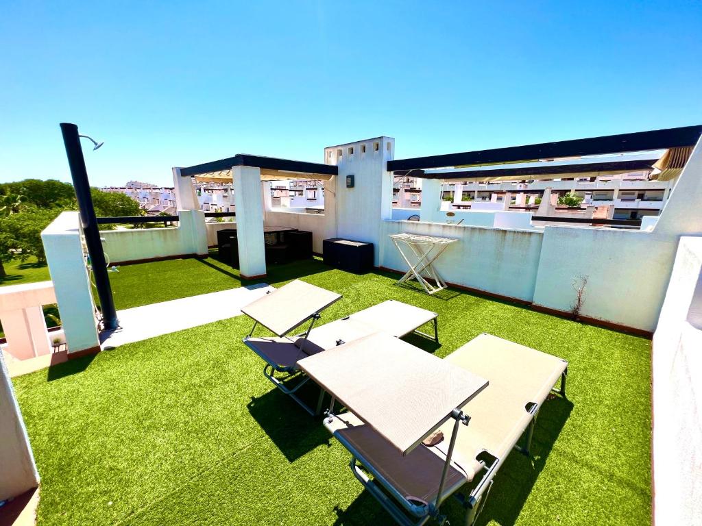 a rooftop patio with grass and tables on a building at Condado de Alhama NARANJOS 7 SV12 in El Romero