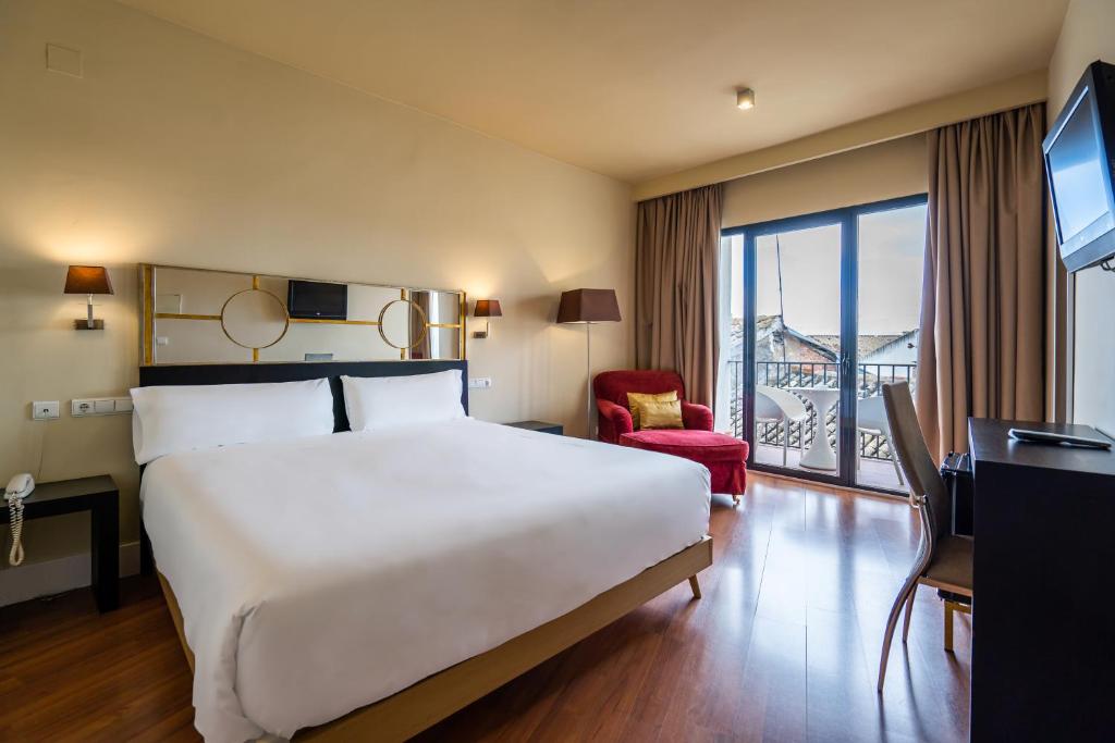 a hotel room with a large bed and a window at YIT El Postigo in Úbeda