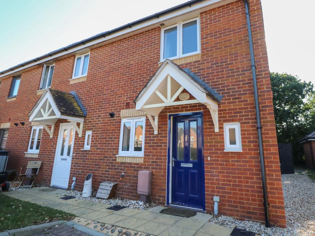 a red brick house with a blue door at 19 Windsurfing Place in South Hayling