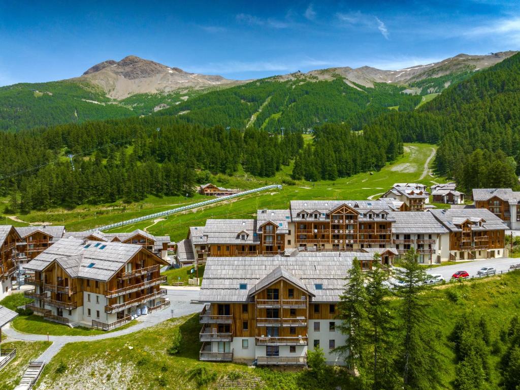 uma vista aérea de um resort com montanhas ao fundo em Noemys Chalets de Bois Méan em Les Orres