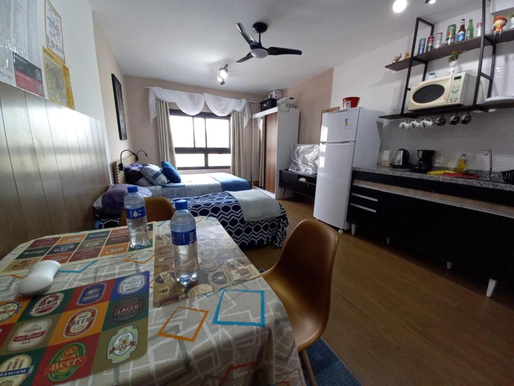 een kamer met een bed en een keuken met een tafel bij Lindo Apartamento na Frei Caneca in Sao Paulo