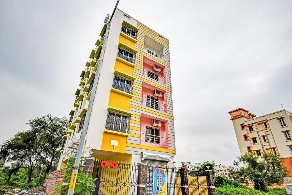 a building with colorful windows and a ladder at Hotel O Maa Residency Near Biswa Bangla in Thākurdwari