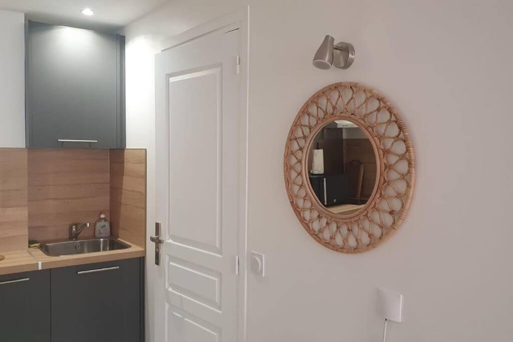 a mirror hanging on a wall next to a kitchen at Studio palais de justice in Rouen