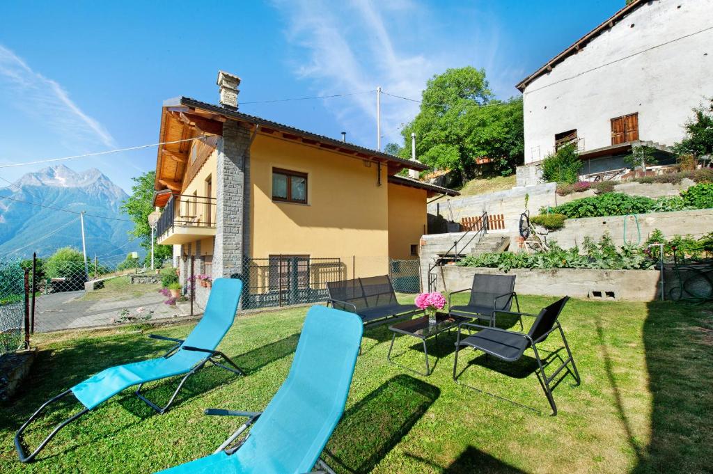 un patio con sillas, una mesa y una casa en Il piccolo nido en Aosta