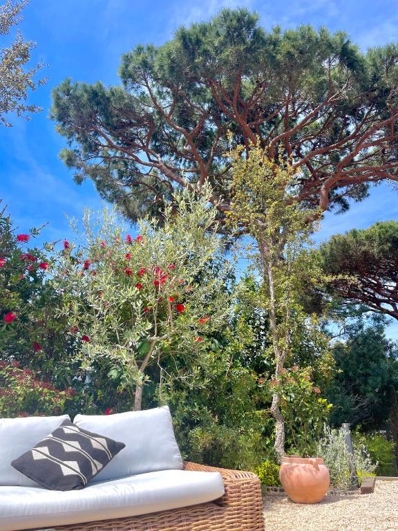 a white couch sitting in front of some trees at Hôtel L'Escalet in Ramatuelle