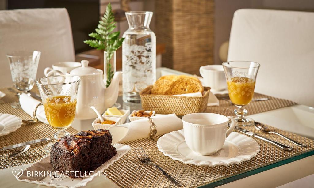 a table with a plate of cake and cups of coffee at Albergo Diffuso Birkin Castello in Cagliari