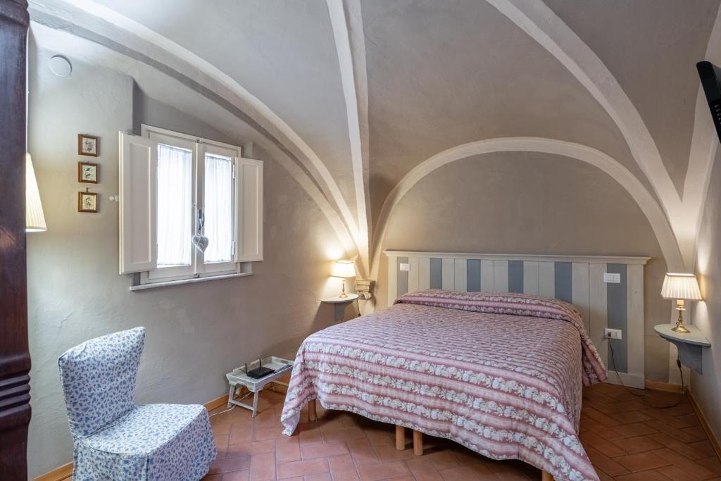 a bedroom with a bed and a chair and a window at Residenza Gatteschi in Pistoia