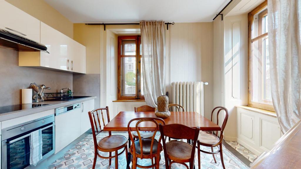 a kitchen with a table and chairs in a kitchen at Architectural gem with vintage charm in La Chaux-de-Fonds