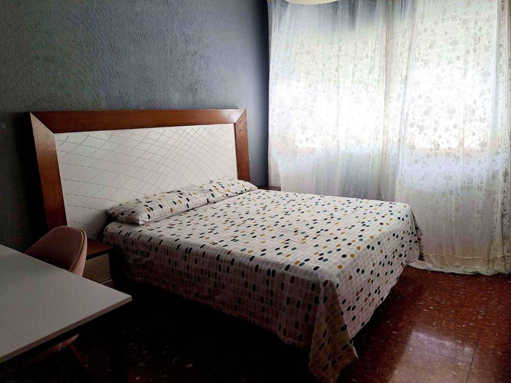 Habitación pequeña con cama y ventana en Genial casa en centro, en Ceuta