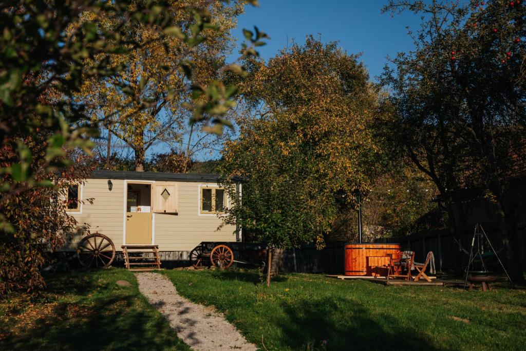 une caravane blanche dans une cour avec une clôture dans l'établissement Jotaferien Transylvanian Shepherdhut with jacuzzi, 