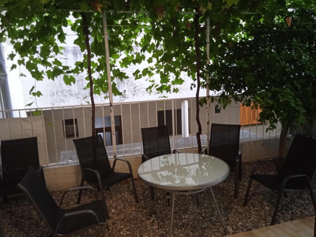una mesa y sillas en un patio bajo algunos árboles en D&D Lausic Apartment, en Dugi Rat
