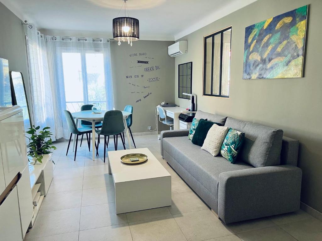 uma sala de estar com um sofá e uma mesa em Nice west cosy flat balcony, near airport, train, beach, public transport, supermarket, comfortable and well equipped em Nice