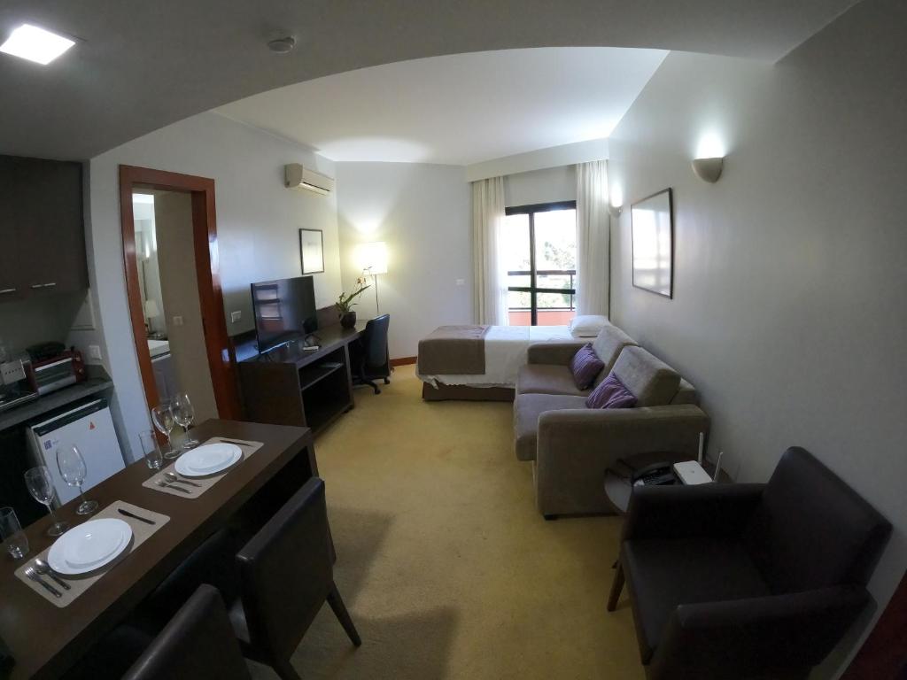 Habitación de hotel con cama y sala de estar. en Bonaparte - Excelente Apartamento#417, en Brasilia