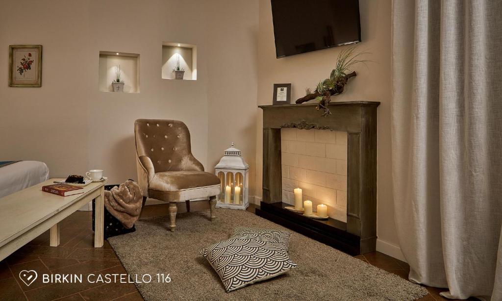 a living room with a chair and a fireplace at Albergo Diffuso Birkin Castello in Cagliari