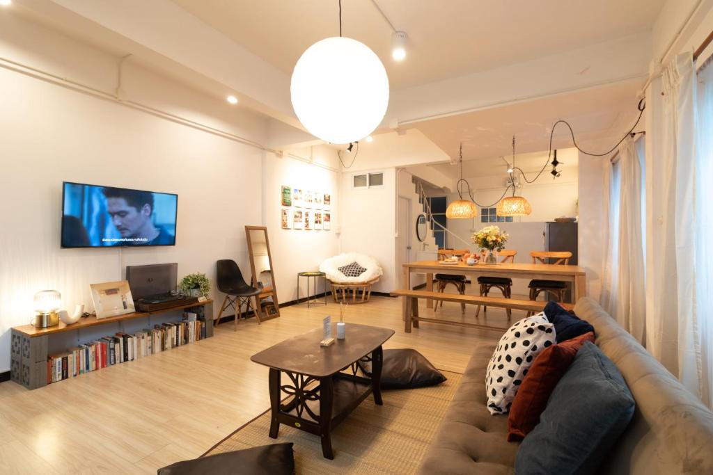 un salon avec un canapé et une table dans l'établissement Merry House Chiang Mai, à Chiang Mai
