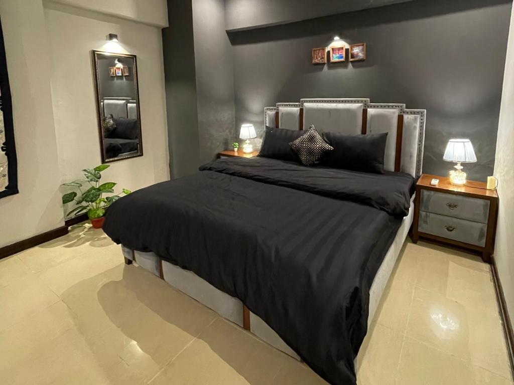 sypialnia z łóżkiem, 2 lampami i lustrem w obiekcie Freddy's Family Apartments w mieście Islamabad