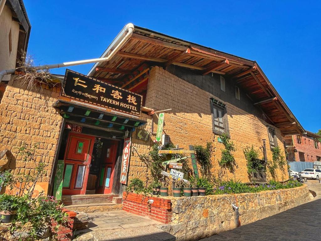 a brick building with a sign on it at Tavern Hostel仁和客栈 in Shangri-La