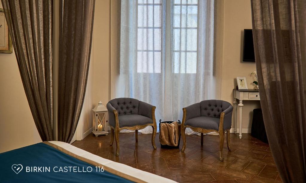 a bedroom with two chairs and a bed and a window at Albergo Diffuso Birkin Castello in Cagliari