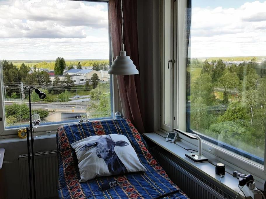una cama con una foto de una vaca en una almohada en una ventana en 60 neliön kaksio 300 m keskustaan en Seinäjoki