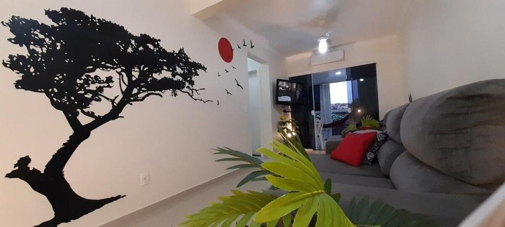 a living room with a tree stencil on the wall at Apenas 5 min das Àguas Termais, lindo apto 204 in Piratuba