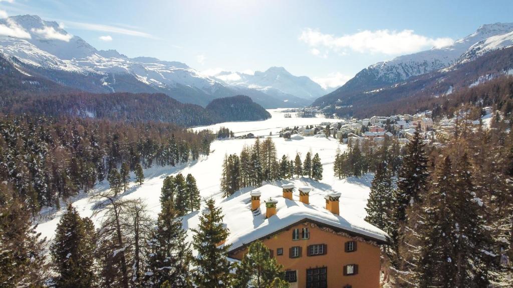 a house in the mountains with snow on the ground at Hotel Chesa Spuondas in St. Moritz