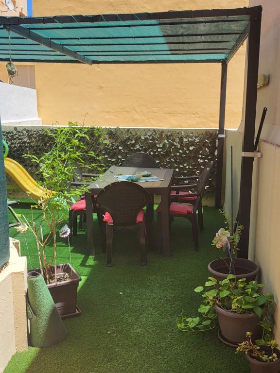 a patio with a table and chairs and potted plants at Piso en San Fernando (Cádiz) in San Fernando