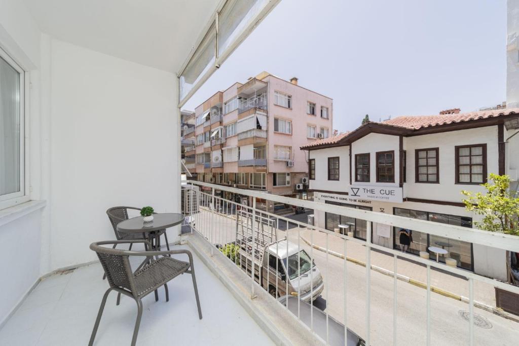 - un balcon avec une table et des chaises dans un bâtiment dans l'établissement Cozy Flat w Balcony 3 min to Hadrian Gates, à Antalya