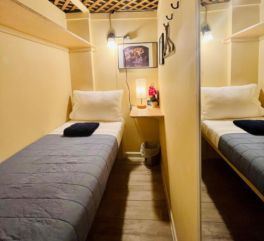 Habitación pequeña con 2 camas y mesa. en New York Spirit Retreats HOSTEL en Nueva York