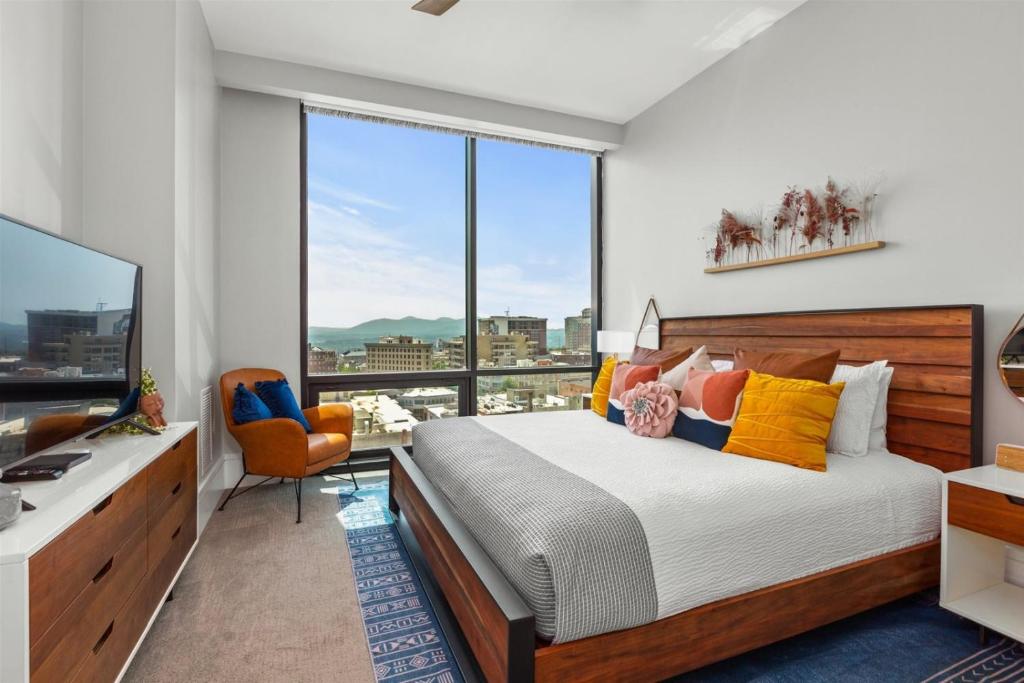 1 dormitorio con cama y ventana grande en 'Mountain Serenity' A Luxury Downtown Condo with Mountain Views at Arras Vacation Rentals, en Asheville
