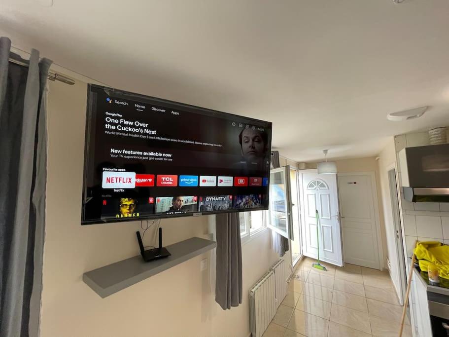 TV de pantalla plana colgada en la pared de la cocina en Platinum Prestige Suit en Sarcelles