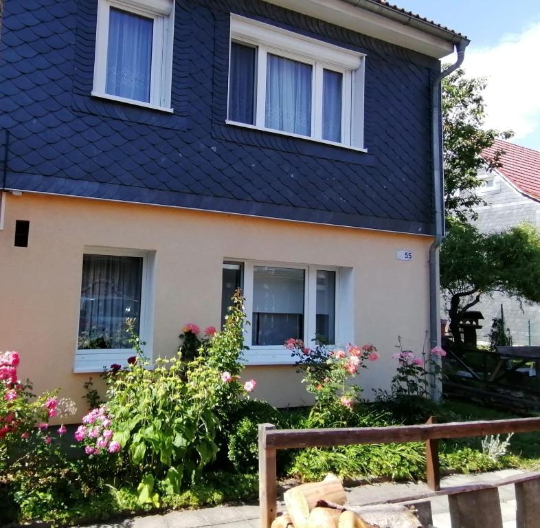 una casa con techo negro y algunas flores en Ferienhaus Am Sommerberg, en Gießübel
