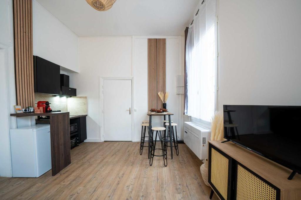 - un salon avec une télévision, une table et des chaises dans l&#39;établissement Bright 30 m near the Place de la Comédie, à Montpellier