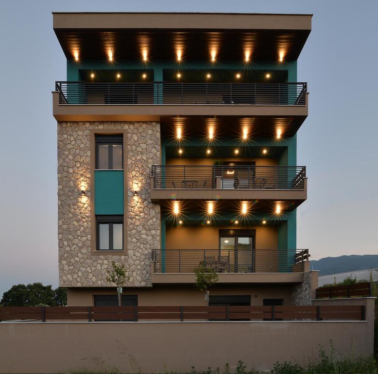 un edificio con balcón con luces encendidas en Niel Holiday Apartments, Panel Hospitality Homes & Villas en Leptokarya