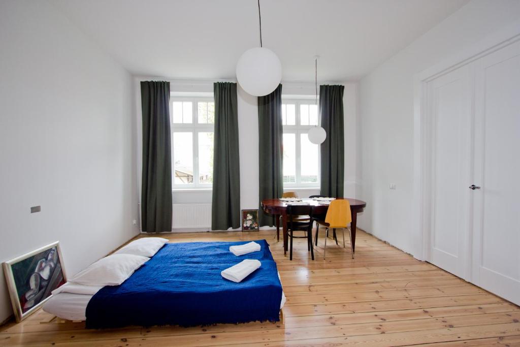 una camera con letto blu e una sala da pranzo di New Port Apartment Gdańsk a Danzica