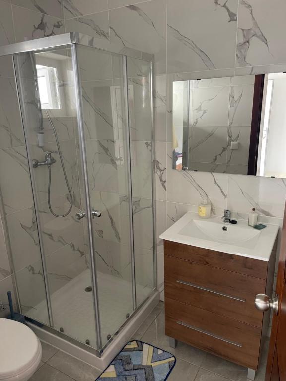 a bathroom with a shower and a sink at Hotel Kenito in São Tomé