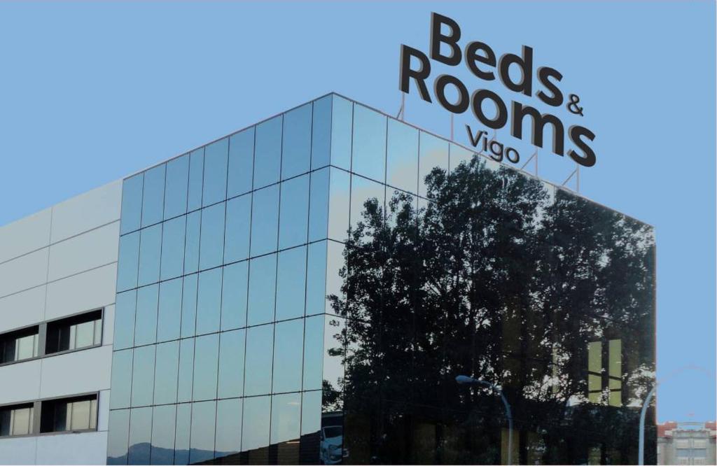 un edificio de cristal con un cartel encima en Vigo Beds & Rooms, en Vigo