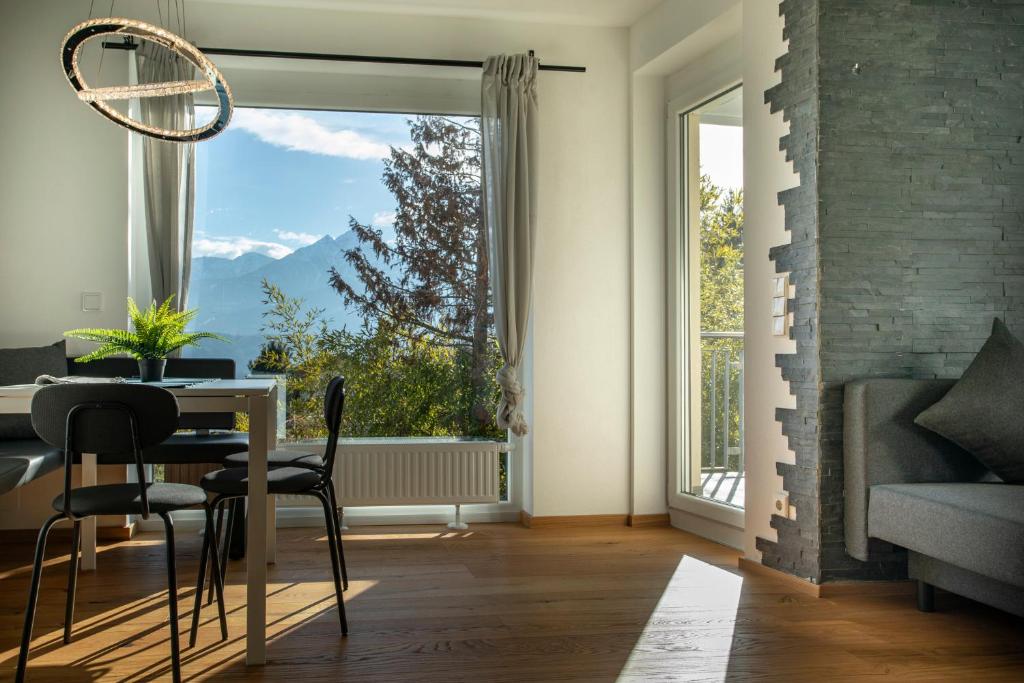 una sala da pranzo con tavolo e una grande finestra di Modern Innsbruck Mountain Apartment I Free Parking a Innsbruck