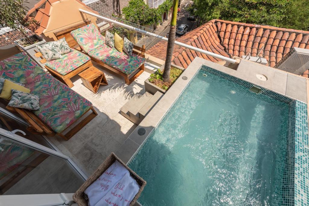 een uitzicht over een zwembad met stoelen en tafels bij Townhouse Boutique Hotel in Cartagena