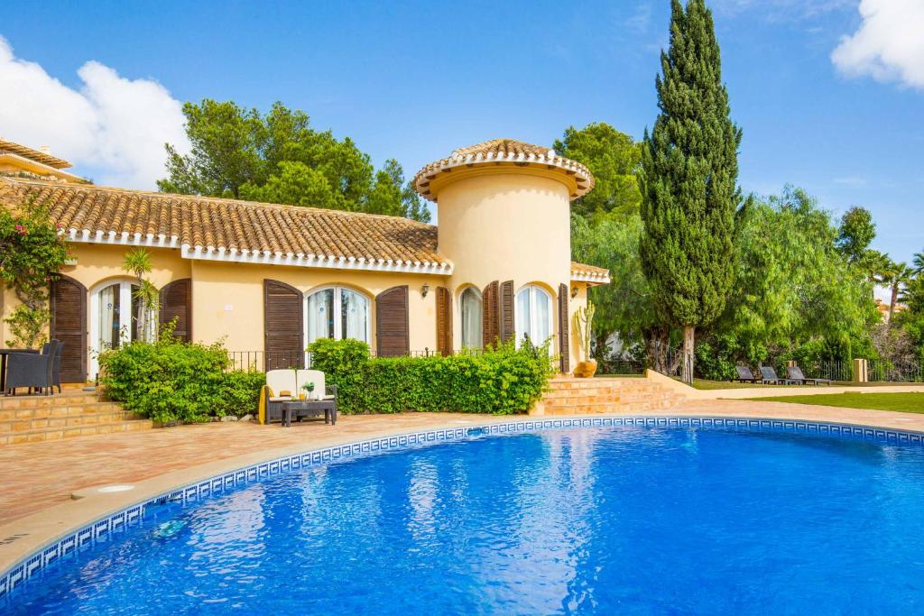 a villa with a swimming pool in front of a house at Villa Tinamar 29 in Cartagena