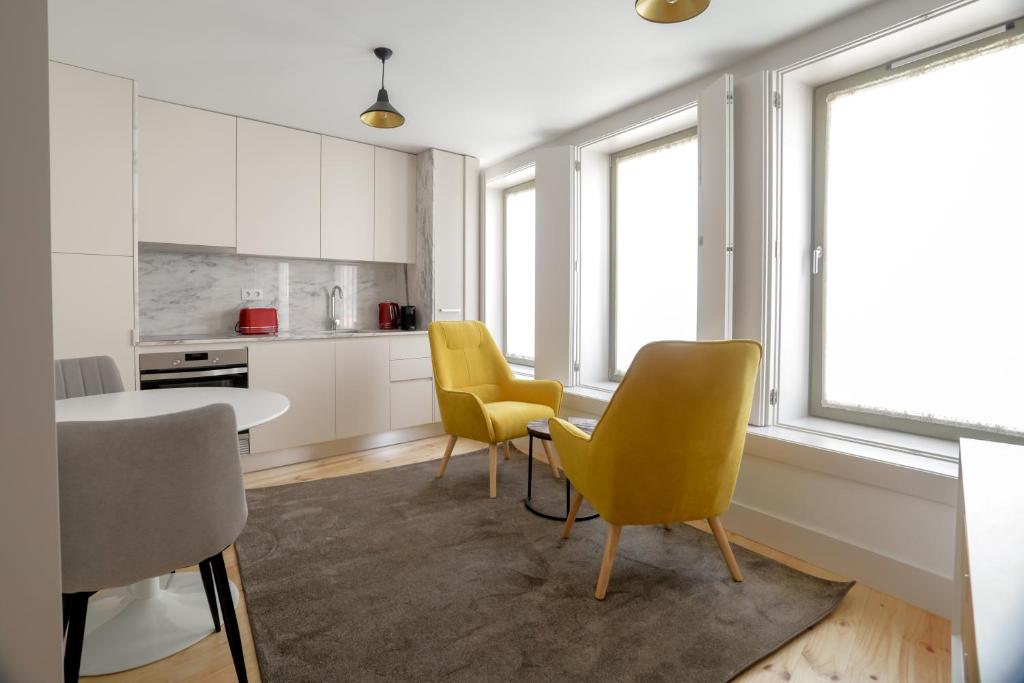 a kitchen with yellow chairs and a table at Trindade Apartments by PHC in Porto