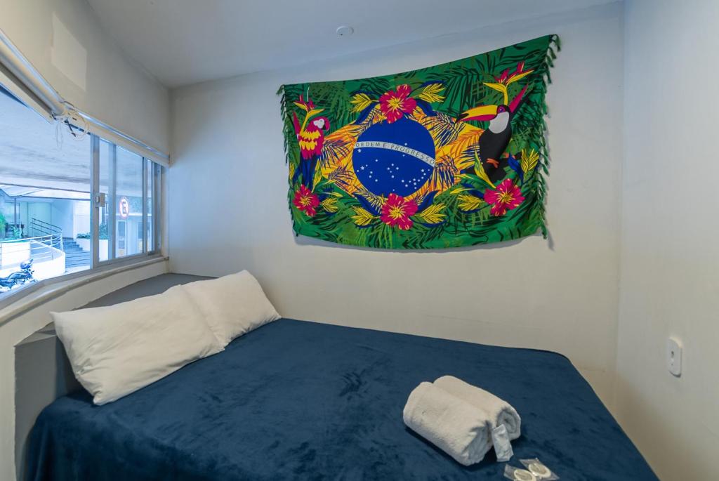 a room with a bed with a flag on the wall at Secreto Quartos in Rio de Janeiro