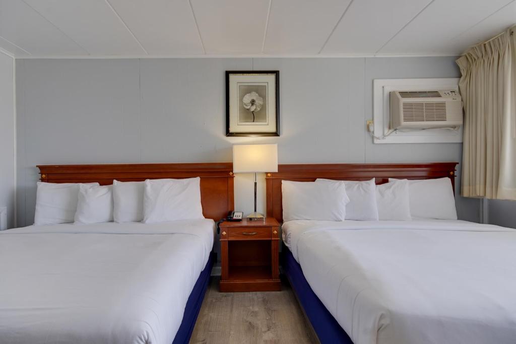 a hotel room with two beds and a lamp at Rideau Oceanfront Motel in Ocean City