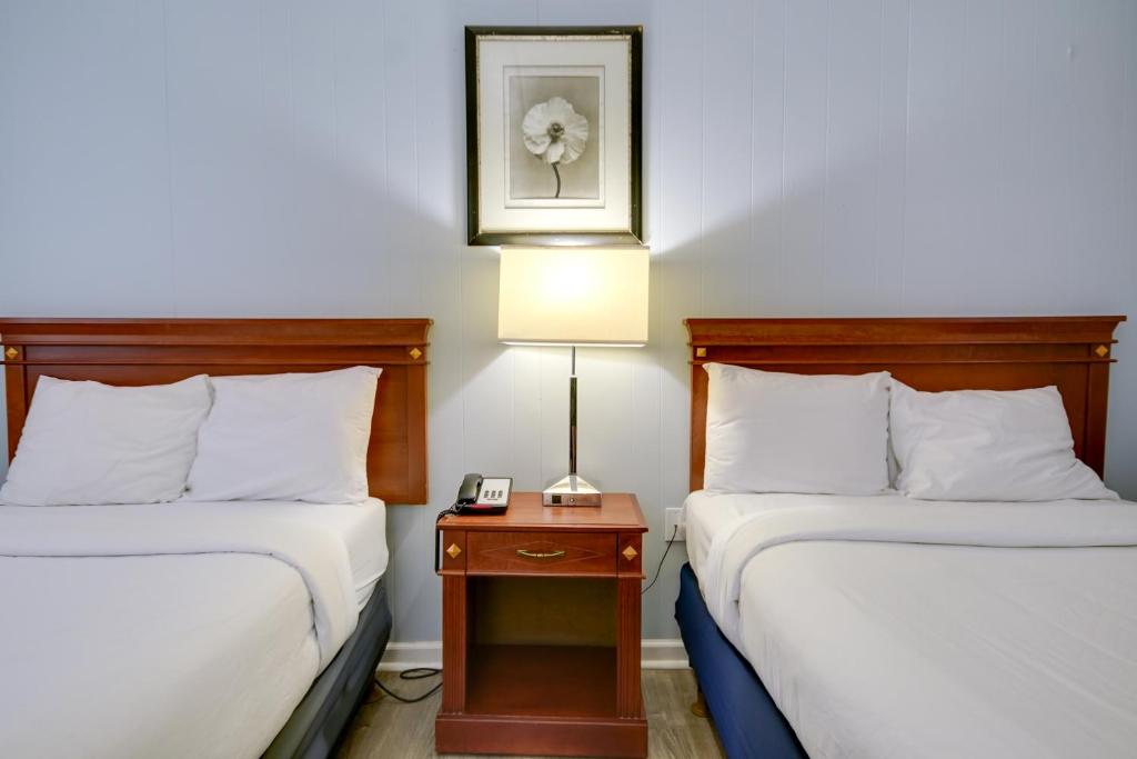 a hotel room with two beds and a lamp on a table at Rideau Oceanfront Motel in Ocean City