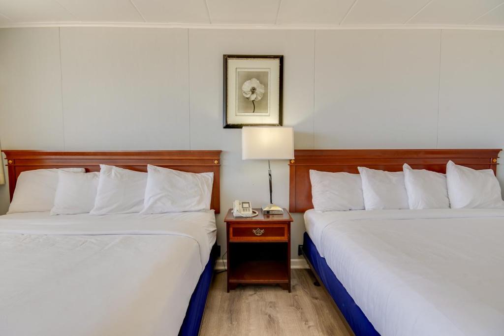 a hotel room with two beds and a table with a lamp at Rideau Oceanfront Motel in Ocean City