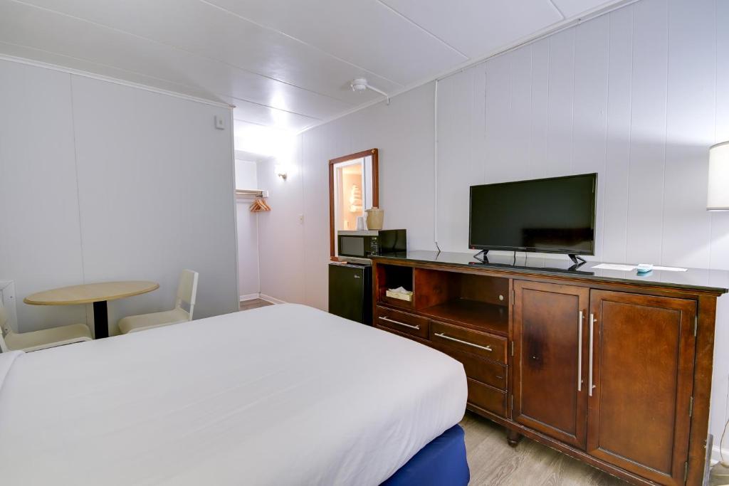a bedroom with a bed and a flat screen tv at Rideau Oceanfront Motel in Ocean City