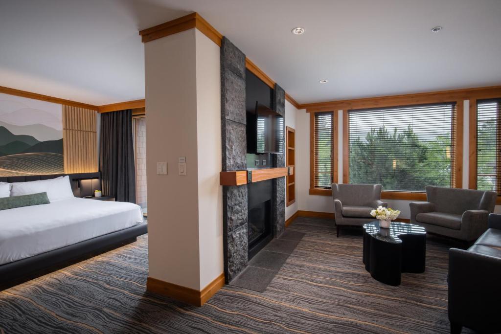 a hotel room with a bed and a fireplace at Nita Lake Lodge in Whistler