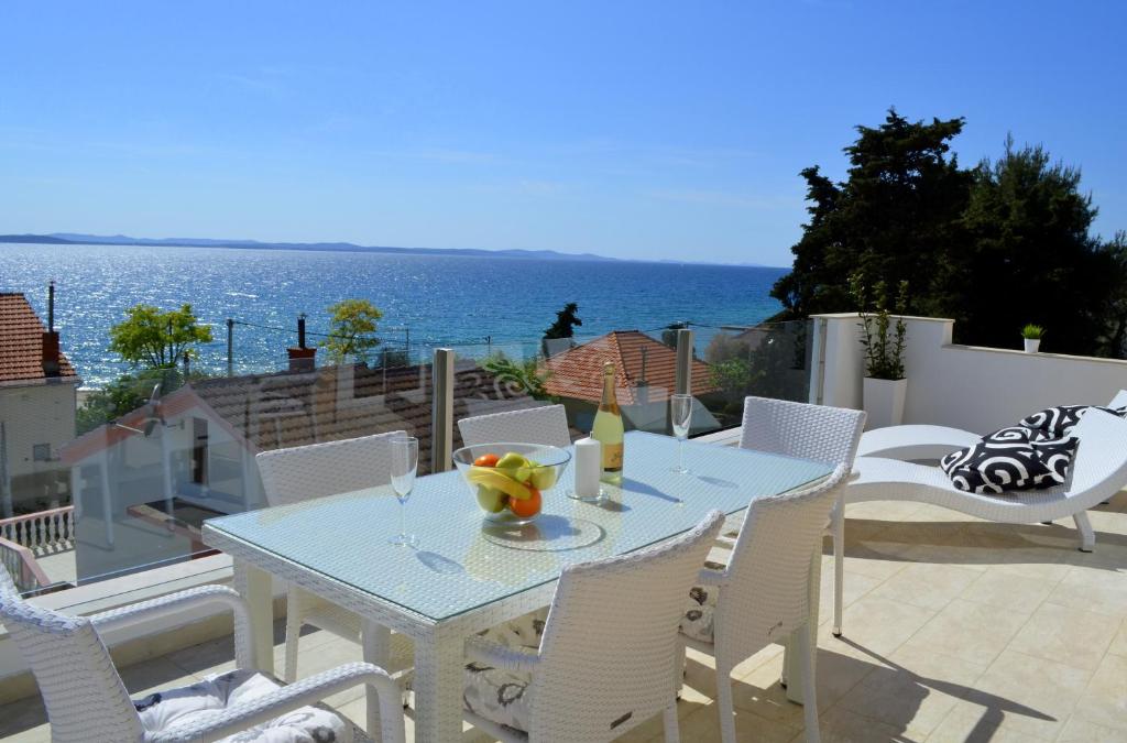 una mesa y sillas en un patio con vistas al océano en Villa Zadar Superior, en Zadar