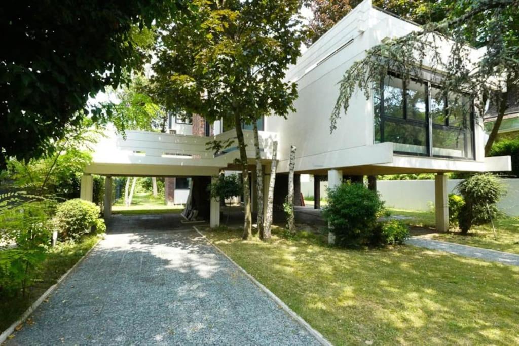 a white house with a tree and a driveway at Maginifique villa d&#39;architecte sur les bords de Marne tout près de Paris in Le Perreux-Sur-Marne