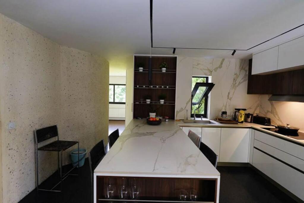 a kitchen with a large white table in a room at Maginifique villa d&#39;architecte sur les bords de Marne tout près de Paris in Le Perreux-Sur-Marne